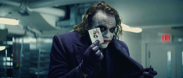 the joker with a playing card in his hand