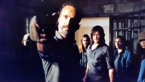 Rick pointing a gun at Dwight
