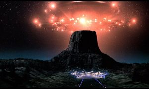 A spaceship hovers over Devil's Tower