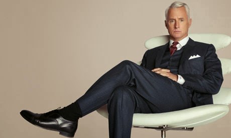 roger sterling sitting in a chair