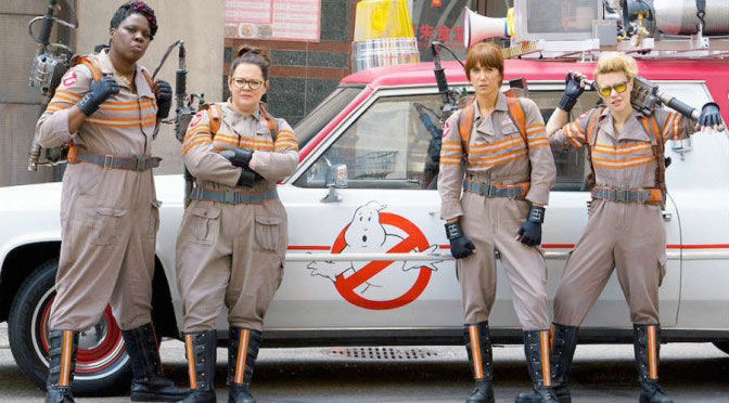 lady ghostbusters in front of ecto 1