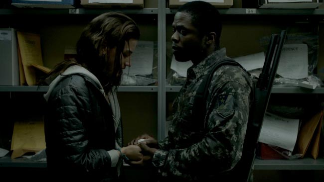 Soldier taking pills from a junkie in The Mist