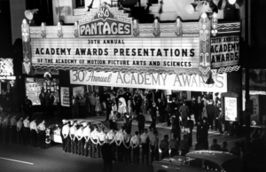 People standing outside the theater hosting the 1958 Oscar Awards.