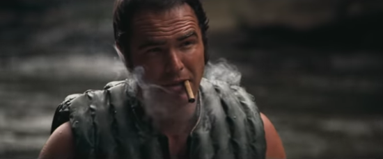 Burt Reynolds smokes a cigar.