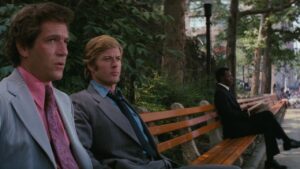 George Segal and Robert Redford sit on a park bench in The Hot Rock.