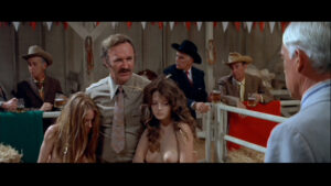 Gene Hackman as Mary Ann who sells women to the highest bidder in Prime Cut.
